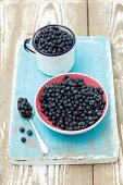 Fresh blueberries in a bowl and in an enamel mug