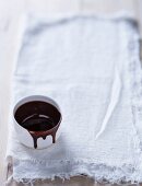 A bowl of chocolate sauce on a linen cloth