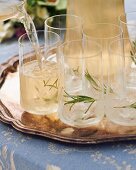 A rosemary drink being poured into glasses