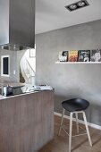 Island counter and bar stool in modern kitchen with concrete-effect walls