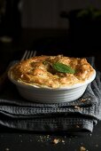 A chicken and mushroom pie in a white baking dish (close-up)