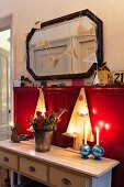 Wooden Christmas trees on console table against red wainscoting