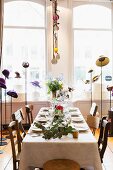 Set table surrounded by various hats on hat stands