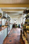 Langgezogene Küche mit Terrakottafliesen und Essplatz