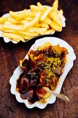 Currywust and chips in paper plates