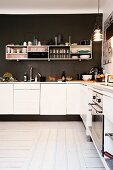 White fitted kitchen and shelves mounted on dark brown wall