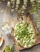 Tarte flambée with asparagus, peas and bacon on a table outside