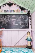 Chalkboard in pastel-coloured wooden play house