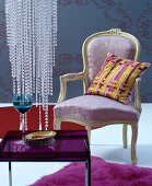 Pastel, Baroque armchair with yellow, striped cushion against blue-grey background with ornate pattern and bead decoration above purple glass table