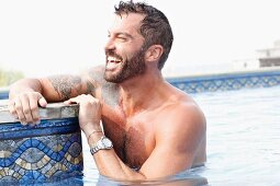 A dark-haired man with a beard in a pool