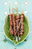 Grilled lamb skewers on a leaf-shaped plate