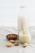 A jar of almond mousse and almond milk in a glass milk