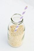 Milchflasche mit Strohhalm und Quinoa