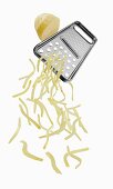 A vegetable grater with grated potato