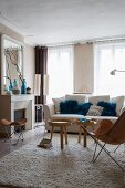 Classic furniture, fireplace and blue scatter cushions in bright, pleasant living room