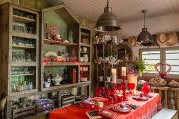 Rot gedeckter Weihnachtstisch im Vintage-Zimmer im Stile eines Gartenhauses
