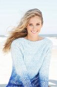 Young woman wearing angora sweater in shades of blue on beach