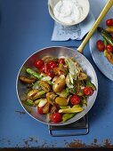 Fried potatoes with green asparagus and cherry tomatoes