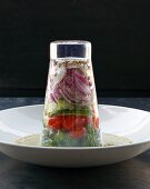 A layered salad in an upside down glass on vinaigrette