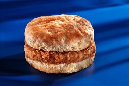 Biscuit mit panierter und gebratener Wurstscheibe