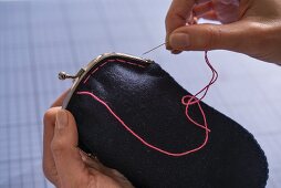 A purse frame being sewn on with staying stitch