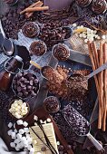 An arrangement of chocolate featuring cupcakes, chocolate chips, cocoa, syrup, marshmallows and cinnamon sticks
