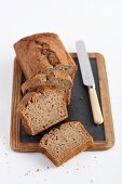 Freshly baked banana bread, sliced, on an old chalkboard