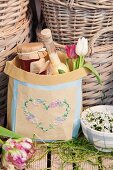 Git bag embroidered with heart motif in front of baskets