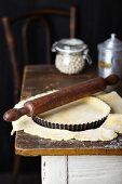 Shortcrust pastry for apple and frangipane tart in a tart tin on a rustic kitchen table