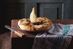 Pizza mit Gorgonzola & Birrnen auf rustikalem Holztisch