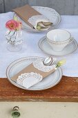 Coffee cup and cake plates on white runner on wooden table