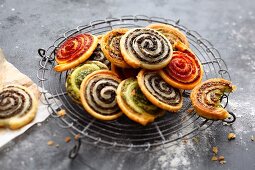 Colourful herb, olive and tomato spiral pastries with Parmesan