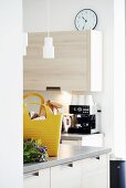 Yellow shopping bag on kitchen counter in front of coffee machine