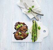 Vegetable and carrot cakes with pine nuts, steamed asparagus and artichoke purée