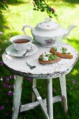 Bruschetta topped with broad beans, goat's cheese, lavender flowers and olive oil served with a cup of tea