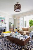 Books on a cube-like coffee table and elegantly patterned oriental carpet in a traditional living room