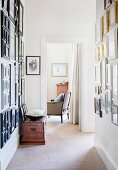 Hallway area with picture galleries, open door in the background and view of antique armchairs