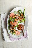 Chicken breast with a guava and barbecue sauce on a bed of lettuce with asparagus and walnuts