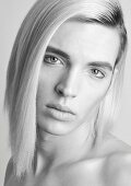 Androgyner junger Mann mit langen blonden Haaren (s/w-Foto)