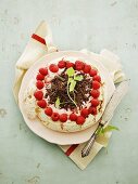 A meringue tart with raspberry cream and fresh raspberries