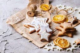 Glazed Christmas star biscuits and dried orange slices on an old newspaper