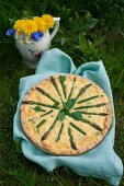 Quiche with asparagus, peas and fresh mint in a garden