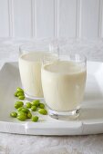 Two glasses of vegan soya milk and green soya beans