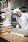 Bäcker in Backstube beim Zubereiten von Teig