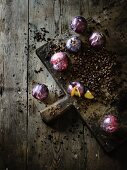 Plums and coffee beans on a wooden chopping board