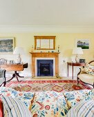 View over sofa to open fireplace flanked by antique tables in rustic, traditional, elegant living room