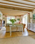 Console table against back of sofa in rustic living room with wood-beamed ceiling and elegant ambiance