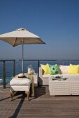 Comfortable outdoor lounge furniture on sun deck with sea view under blue sky