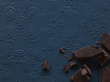 Pieces of chocolate on a blue surface