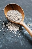 White chia seeds on a wooden spoon